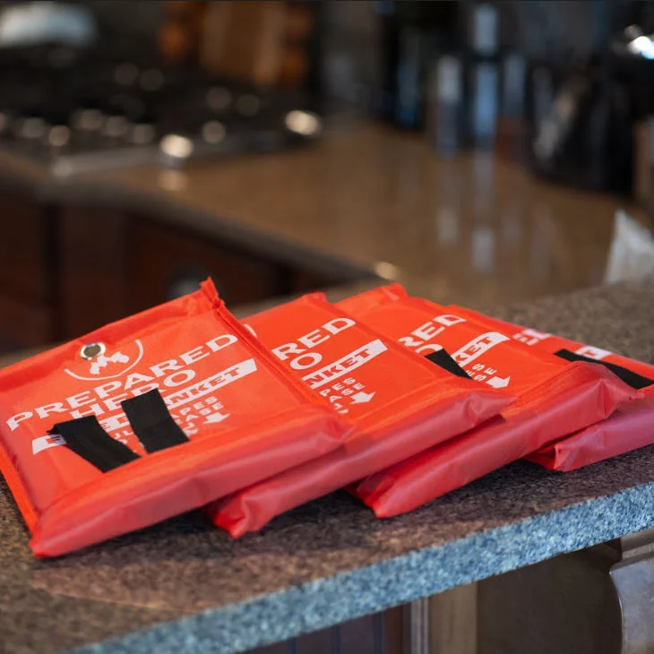 Prepared Hero fire blanket mounted inside a kitchen cabinet near the stove